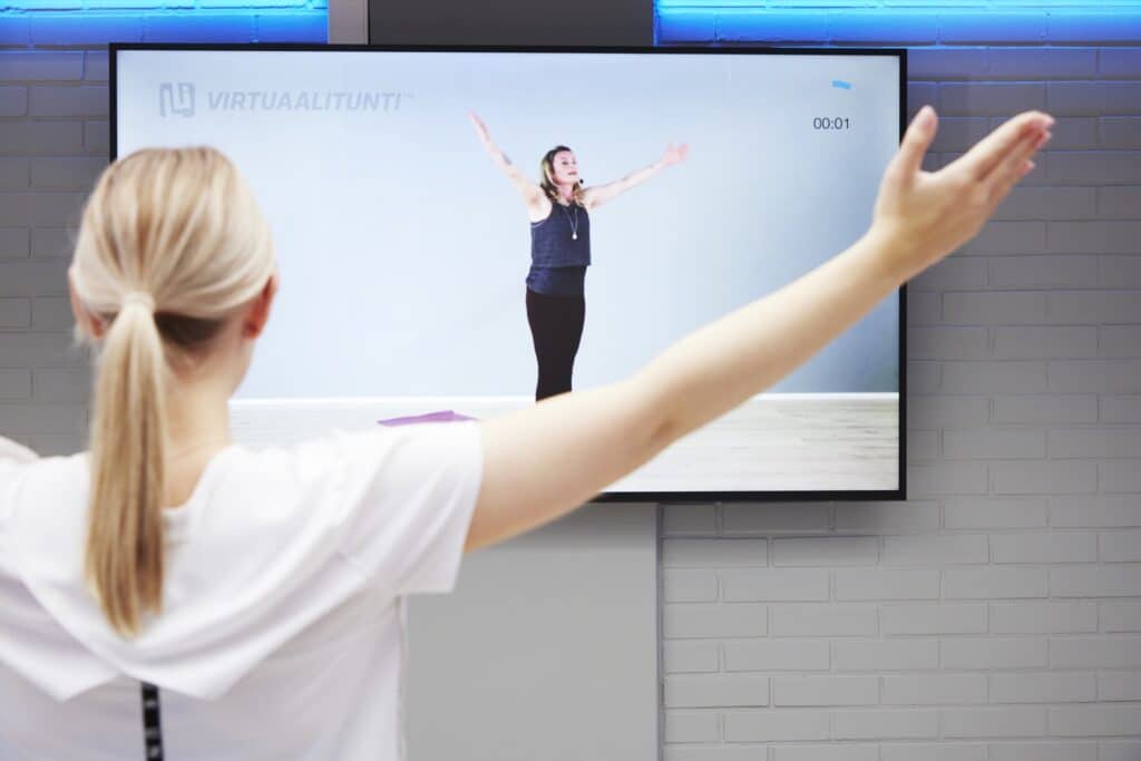 Nuori nainen tekemässä virtuaalitreeniä
